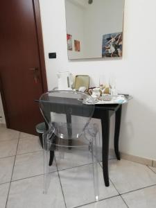 a glass table with a glass chair in a room at Residenza Del Sole in Surbo