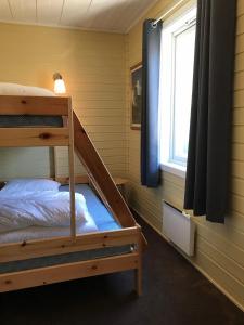 a bedroom with two bunk beds and a window at Nedre Stensgården in Røros