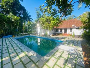 an image of a swimming pool in front of a house at Babira Brookside Heritage Resort in Kumarakom