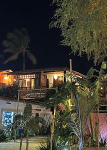 a house on the beach at night at Pousada Coral Negro in Jericoacoara