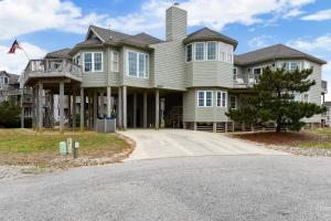 a large house with a driveway in front of it at The Tappan at Ships Watch in Duck
