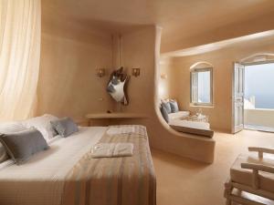 ein Schlafzimmer mit einem großen Bett und einem Fenster in der Unterkunft Dome Santorini Resort & Spa in Imerovigli