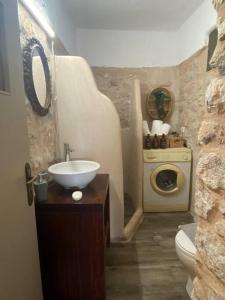 a bathroom with a sink and a washing machine at Λαγκάδι Μάνης in Koíta