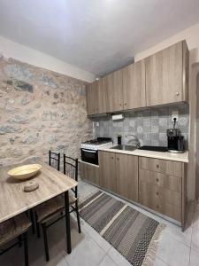 a kitchen with wooden cabinets and a wooden table with a tableablish at Λαγκάδι Μάνης in Koíta