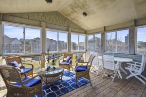 a large screened porch with chairs and a table at The Wythers at Ships Watch in Duck