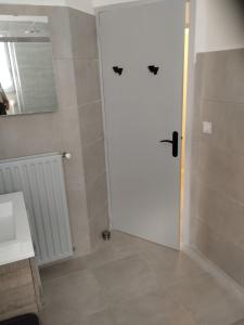 uma casa de banho com uma porta branca e um espelho em appartement 4 couchages renovés entièrement em Cavaillon