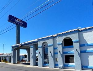 a blue and white building with a sign in front of it at Baymont by Wyndham Kingman in Kingman