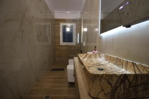 a bathroom with a large marble sink and a toilet at Vila Mario Himare in Himare +43 photos