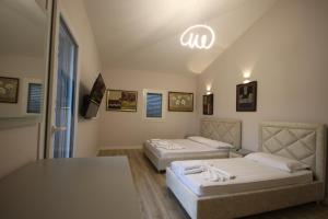 a room with two beds and a table in it at Vila Mario Himare in Himare