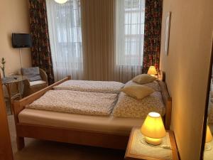 ein Schlafzimmer mit einem Bett und zwei Lampen auf einem Tisch in der Unterkunft Hotel Restaurant Zumbusch in Bad Bertrich