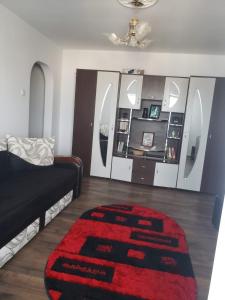 a living room with a black couch and a red rug at Apartament 2 Camere in Roman