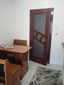 a room with a wooden table and a door at Apartament 2 Camere in Roman