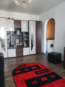 a living room with a red rug on the floor at Apartament 2 Camere in Roman