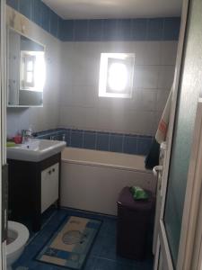 a bathroom with a sink and a tub and a toilet at Apartament 2 Camere in Roman