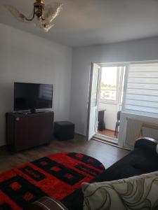 Una sala de estar con un sofá y un televisor de pantalla plana. en Apartament 2 Camere, en Roman