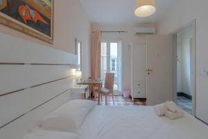 1 dormitorio con 1 cama blanca, mesa y sillas en Casa De Rollo, en Noto