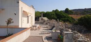 eine Terrasse mit einem Gebäude und einer Felswand in der Unterkunft Casa Marchello in Castrignano del Capo
