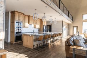 a large kitchen with a bar with stools at Teton Family Retreat- West Dome in Ashton