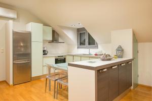 a kitchen with white cabinets and a table in it at Louloudis Boutique Hotel in Skala Rachoniou