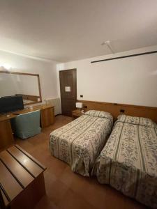 a hotel room with two beds and a desk at Villa Felcaro - Relais, Lodge & Restaurant in Cormòns