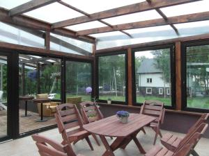 a screened in porch with a wooden table and chairs at Villa Banita in Ustka