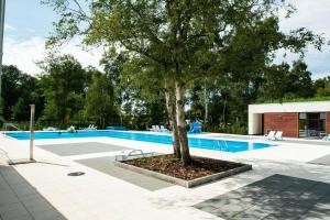 a tree sitting next to a swimming pool at Apartamenty Bryza in Kołobrzeg