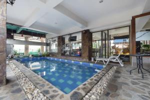 a large swimming pool with a table and chairs in a building at 21 hotel in Pattaya Central