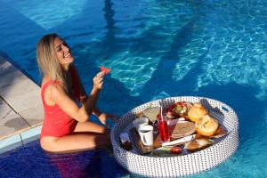 Bali Hai Island Resort في Balian: وجود امرأة تأكل الطعام بجانب المسبح