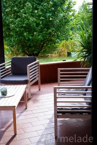 2 Stühle und eine Couch auf einer Terrasse in der Unterkunft Marmelade in Zagarolo