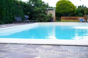a swimming pool with blue water in a yard at Marmelade in Zagarolo +7 photos