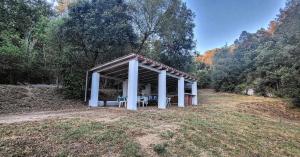a pavilion in the middle of a field with trees at Casa Rural Can Nonell del sot in Vallgorguina
