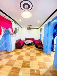 Casa Marisco في شفشاون: غرفة معيشة مع الأرائك الأرجوانية والجدران الزرقاء