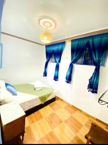 Casa Marisco في شفشاون: غرفة نوم بسرير ونافذة ذات ستائر زرقاء