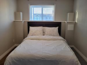 Łóżko w małym pokoju z oknem w obiekcie Full 1-bedroom apartment w mieście St. John's