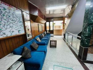 a waiting room with blue couches in a building at Hotel Amar in Mussoorie