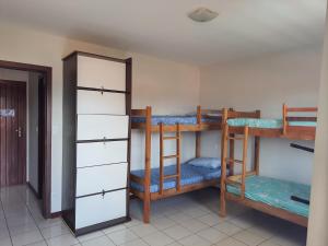 a room with three bunk beds and a mirror at Hostel Atairú in Natal