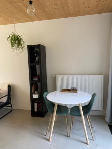 a white table and chairs in a room at de graslelie in Schoten