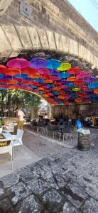 a bunch of colorful umbrellas hanging over tables and chairs at Casa Mediterraneo in Catania