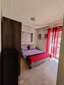 una camera con un letto con copriletto rosso di Les Perles de Tamaris a Tamaris