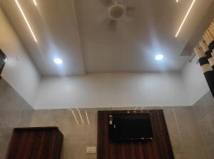 Cette chambre dispose d'un plafond et d'une télévision à écran plat. dans l'établissement Green leaf BnB, à Amritsar