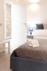 1 dormitorio blanco con 1 cama con manta marrón en Gli Imperiali, en Latiano