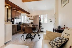 a kitchen and living room with a table and chairs at Cocon dans la vieille ville in Villefranche-sur-Mer