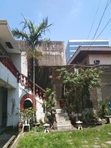 a building with stairs and a palm tree in a yard at The Terrace Room in Manila