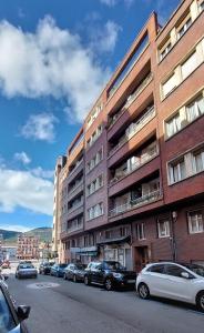 un edificio con coches aparcados al lado de una calle en Zuvillaga 14, en Oviedo