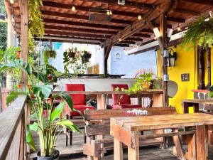 un patio con bancos de madera, mesa y sillas en Panama House Bed & Breakfast en Panamá