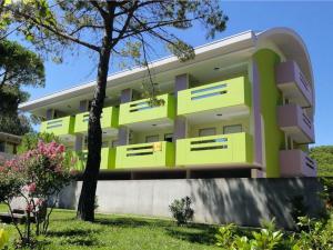 a yellow and white building with a tree in front of it at Residence Bright Star in Bibione