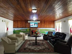 duży salon z kanapami i stołem w obiekcie Estancia del Bosque Forest Guest House w mieście Siguatepeque