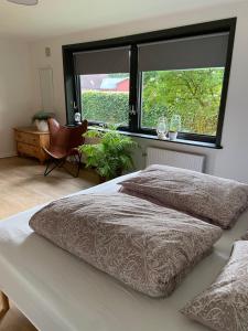 1 dormitorio con 2 camas y ventana grande en Toghale, en Tønder