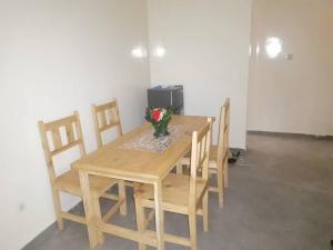 a wooden table with chairs and a vase of flowers on it at Chez Manga in Ziguinchor