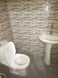 uma casa de banho com um WC e um lavatório em Chez Manga em Ziguinchor